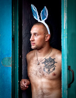 A New Orleans Male Dancer With Velveteen Rabbit Ears, Shirtless And Tattooed, Looks Out On Bourbon Street In This Commercial Environmental Portrait Or Street Photograph By Brian Buckner Photography.