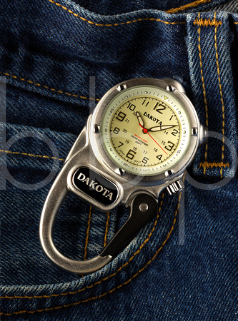 A Dakota Mini Clip Micro Light Watch is shown resting by the pocket of a pair of blue jeans advertising it's use in this commercial product advertising photograph by Brian Buckner Photography.