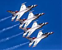 The U.S. Air Force Thunderbirds exhibition flying team cruises by at 700 miles per hour under a blue sky in this commercial aerial photograph by Brian Buckner Photography, Shreveport, Louisiiana.