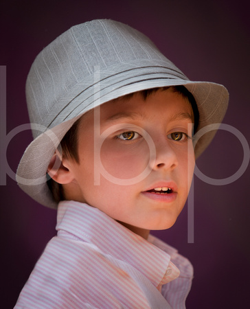 A Young Boy Is Posed Wearing A Hat And Then Photographed Under Very Soft Light in this professional commercial child portrait photograph by Brian Buckner Photography, Shreveport, Louisiana.