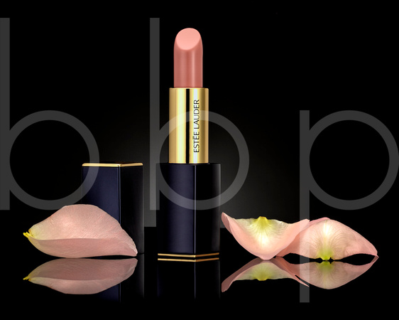 Estee Lauder Lipstick is shown with soft rose petals on black acrylic in this commercial product advertising photograph by Brian Buckner Photography, Shreveport, Louisiana.