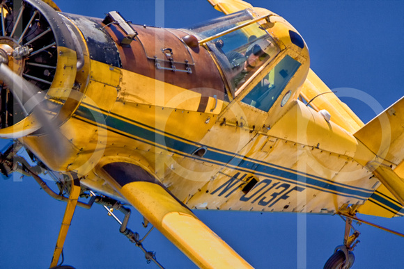 A very close shot of a cropduster pilot in his white helment and aviation sunglsses in his cockpit in this commercial aerial photograph by Brian Buckner Photography, Shreveport, Louisiana.
