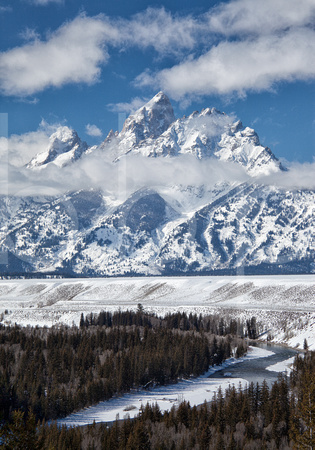 Wispy White Clouds Of Winter Accent The Snow Covered Peak Of The Grand Teton In The Rocky Mountains In This Commercial Landscape Photograph By Brian Buckner Photography, Shreveport, Louisiana.