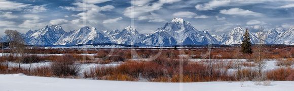 A Striking Wide Panoramic View Of A Cloud Studded Icy Blue Sky And Snow Covered Grand Teton Range is shown in this Commercial Panoramic Landscape Photograph By Brian Buckner Photography, Shreveport.
